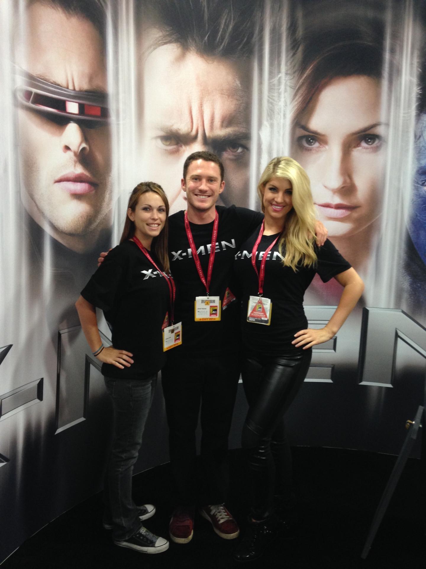 X-Men Comic Con event workers pose in front of movie poster